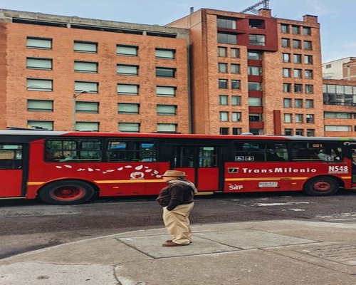 Commuter waiting calmly at a TransMilenio station maintaining good posture